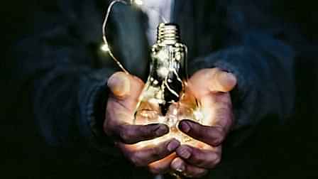 man holding incandescent bulb